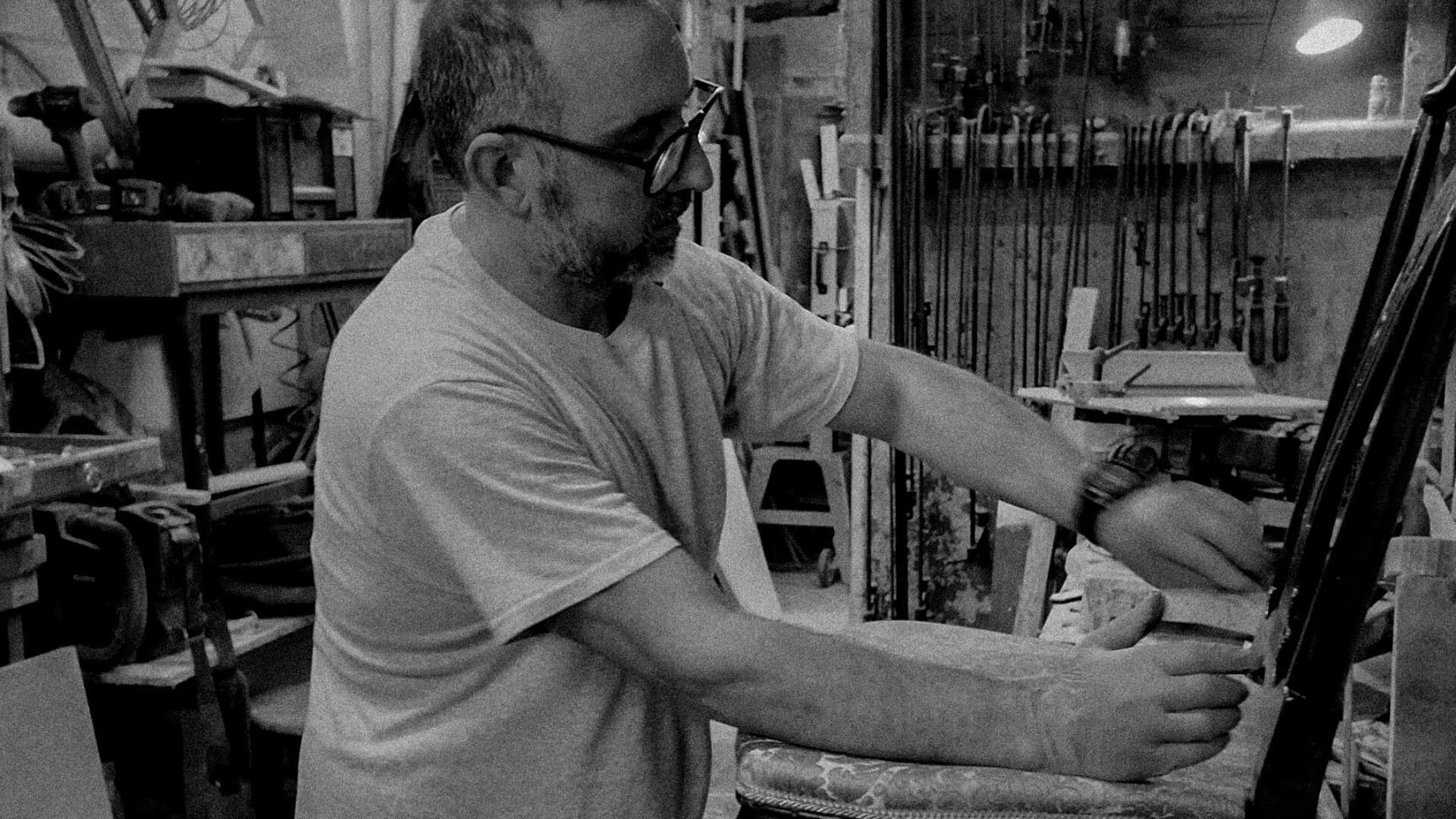 Leonardo Lorenzon all'opera nel restauro di una sedia in legno antica